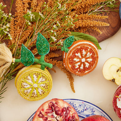Fair trade citrus-themed ornament with intricate bead detailing and natural linen backing, full of zesty charm.