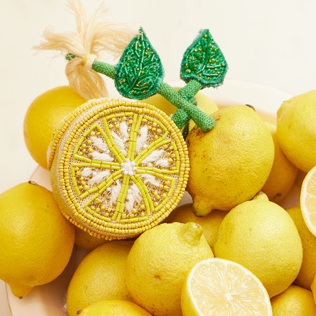 Bright citrus ornament featuring intricate beadwork, green leaves, and a lemon blossom tassel, handcrafted in India.