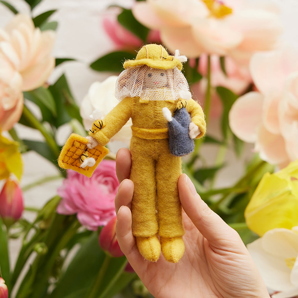 Hand-felted beekeeper ornament with amber hair and fair complexion, wearing protective suit