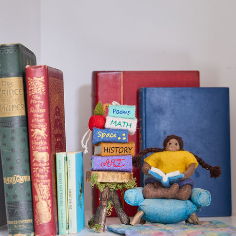 Handmade felt ornament featuring a miniature stack of colorful books, meticulously crafted from natural wool using traditional felting techniques. This eco-friendly and lightweight ornament adds a cozy, literary touch to holiday trees, bookshelves, or reading nooks. A charming gift for bookworms, teachers, and students, perfect for any occasion or year-round decor.