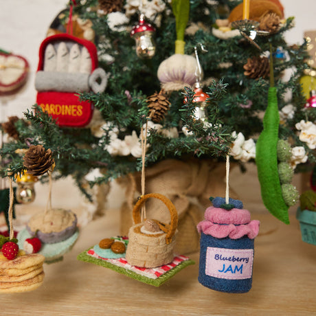 Hand-felted blueberry jam jar ornament with a gingham-style lid and a bunch of plump felt blueberries on top. Made from merino-blend wool, this 3-inch tall ornament is a charming, summer-inspired gift for bakers and brunch lovers. Perfect for cottagecore décor, holiday trees, or breakfast-themed bundles.  Hanging on a christmas trip.