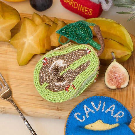 Hand-beaded pear ornament in golden and green tones, with natural linen backing and shimmering details, handmade in India.