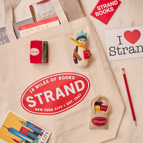 Handmade felt ornament shaped like a miniature book, featuring a red cover with the classic Strand Bookstore logo. The book opens to reveal three pages with whimsical, hand-stitched NYC scenes, including yellow taxis, skyscrapers, and pigeons with pizza. Crafted from felted wool, this ornament celebrates the magic of New York City and The Strand, making it a perfect gift for NYC enthusiasts, book lovers, and Strand fans. Ready to hang with a string attached.