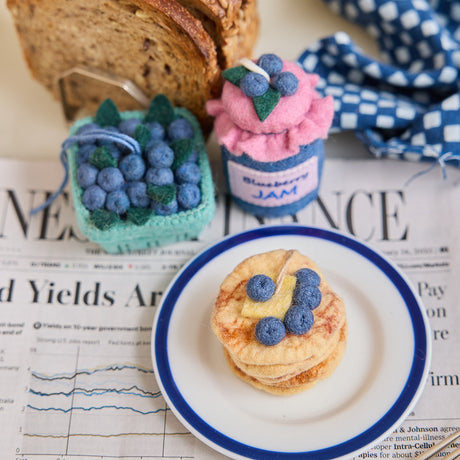 Hand-felted blueberry jam jar ornament with a gingham-style lid and a bunch of plump felt blueberries on top. Made from merino-blend wool, this 3-inch tall ornament is a charming, summer-inspired gift for bakers and brunch lovers. Perfect for cottagecore décor, holiday trees, or breakfast-themed bundles.