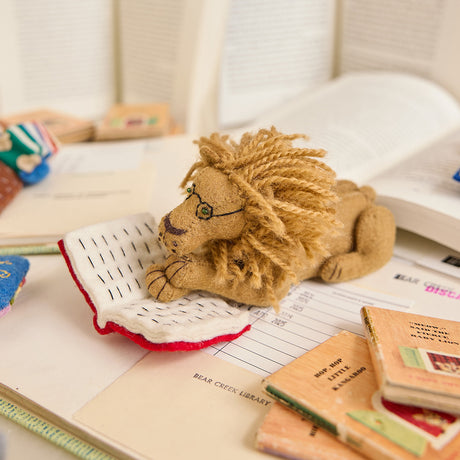 Handmade felt ornament of a wise lion wearing tiny felt glasses, absorbed in a large red book. Crafted from natural wool, this charming lion adds a storybook touch to holiday trees, reading nooks, or cozy corners. A delightful gift for readers, teachers, librarians, or anyone who loves books and imagination. Each ornament is unique, crafted with care using traditional felting techniques.