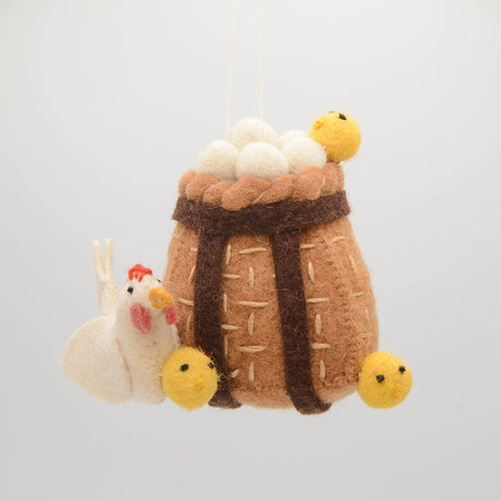 Adorable felt ornament of a hen with baby chicks and eggs in a basket, ideal for farmhouse spring decorations.