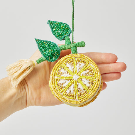 Sunny yellow lemon ornament with beaded embellishments and tassel, perfect for fresh and festive gift presentation.