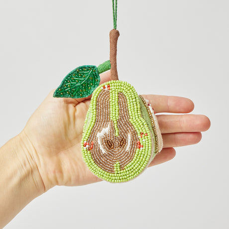 Exquisite pear ornament with beaded craftsmanship and linen backing, honoring nature’s bounty and artisan traditions.