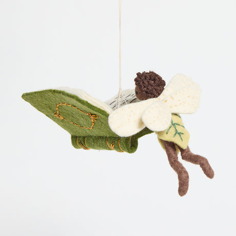 Handmade felt ornament of a fairy with delicate wings and a leafy green tunic, reading an oversized open book embroidered with whimsical details. Crafted from merino-blended wool, this limited-edition ornament is full of storybook charm. Perfect for fairy collectors, book lovers, and dreamers, it brings a magical, literary touch to bookshelves, holiday trees, or cozy reading spaces. Ready to hang with a string attached.