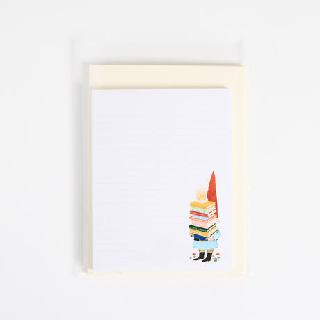 A whimsical reading-themed stationery set, including a notepad, bookmarks, and notecards. Each piece features charming illustrations of a lion reading, a gnome with a book, and a fairy immersed in a story, all drawn in warm, detailed artwork. Printed on natural white textured paper, this set is perfect for journaling, letter writing, or marking your place in a book. A delightful gift for readers, teachers, and those who appreciate a touch of literary magic. Gnome with books notecard