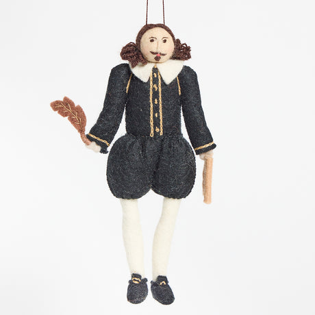 Hand-felted wool ornament of William Shakespeare, featuring the playwright in a classic doublet and hose with a feathered cap and a felt manuscript in hand. Crafted from natural merino-blend wool, the ornament captures his expressive posture and literary charm. Includes a string for hanging and measures approximately 7.5 inches tall.