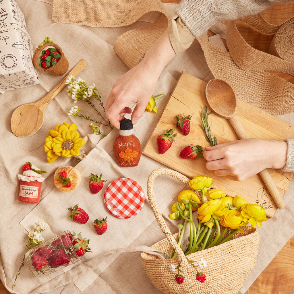 Lightweight raffia basket for kids with hand-stitched fruit, perfect for gathering or gifting.