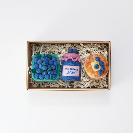Blueberry-themed felt ornament gift set in a kraft box with crinkle paper. Includes a felt blueberry jam jar, blueberry pint basket, and blueberry pancake stack. Handmade from wool felt using traditional needle-felting. Fair trade and ready to hang.