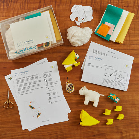 Handmade felt DIY kit from Craftspring’s DIY Kits Collection, featuring spring lamb ornaments in yellow rain boots and raincoats—a creative, hands-on project perfect for learning and making together with kids.
