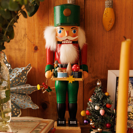 Traditional Christmas decor from Craftspring’s German Collection, featuring a wooden nutcracker and a mini Christmas tree with baubles—heirloom-quality pieces, handmade in Germany using time-honored craftsmanship.