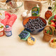 Felt blueberry pint ornament with hand-felted blue berries in a soft green wool basket laying next to a bowl of fresh blueberries. Handmade from natural wool felt using traditional needle-felting. Fair trade and ready to hang.