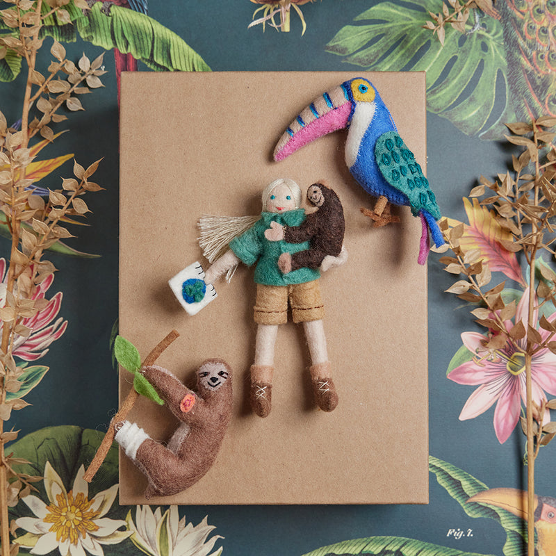 Felt ornament of Jane Goodall holding a chimp and notebook, dressed in field attire.

