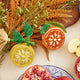 Fair trade citrus-themed ornament with intricate bead detailing and natural linen backing, full of zesty charm.