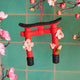 Handcrafted felt ornament of a red Japanese torii gate with cherry blossoms, symbolizing spring and spiritual renewal. Ethically made by artisans in Kyrgyzstan.

