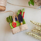 Hand-felted gardening tool bag ornament with felt trowel, gloves, beetroot, and carrots