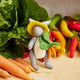 Whimsical felt bunny with vegetable bundle – handmade spring ornament with stitched details and woodland charm.