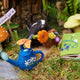 Whimsical felt skunk with spring flowers – handcrafted wool ornament perfect for garden gifts or nursery decoration.
