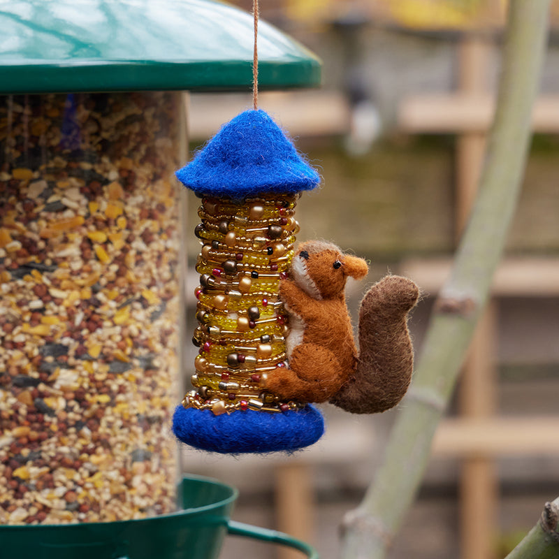Hand-felted squirrel ornament with beaded bird feeder – handmade wool garden decor from the Gardening Collection.