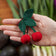 Hand-felted cherry ornament with red wool cherries, green leaf, and stem