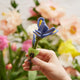 Close-up of hand-felted iris petals with detailed stitching and perched firefly