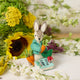 Handmade wool ornament of Peter Rabbit, featuring the beloved children's book character sitting with a carrot in one paw and an embroidered book on his lap. He wears his signature blue jacket, crafted with detailed stitching. Made from natural felted merino-blend wool, the ornament is ready to hang and sized approximately 4.5 inches tall.