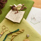 Design process for a felt ornament of a fairy with delicate wings and a leafy green tunic, reading an oversized open book embroidered with whimsical details. Crafted from merino-blended wool, this limited-edition ornament is full of storybook charm. Perfect for fairy collectors, book lovers, and dreamers, it brings a magical, literary touch to bookshelves, holiday trees, or cozy reading spaces. Ready to hang with a string attached.