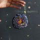 Beaded galaxy Christmas ornament featuring spiral Milky Way design with detailed embroidery. Handmade satin decoration for stargazers and space lovers.