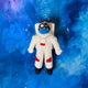 Space-themed astronaut ornament made from wool felt, featuring stitched stars and helmet. Ideal for STEM gifts, holiday décor, and science classrooms.

