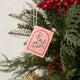 Hot pink felt ornament shaped like a small book, featuring delicately embroidered open pages. Inspired by the beloved Brooklyn bookstore Books Are Magic, this hand-felted wool ornament includes a hanging string and measures approximately 2.5 inches tall. A colorful tribute to the joy of reading and storytelling
