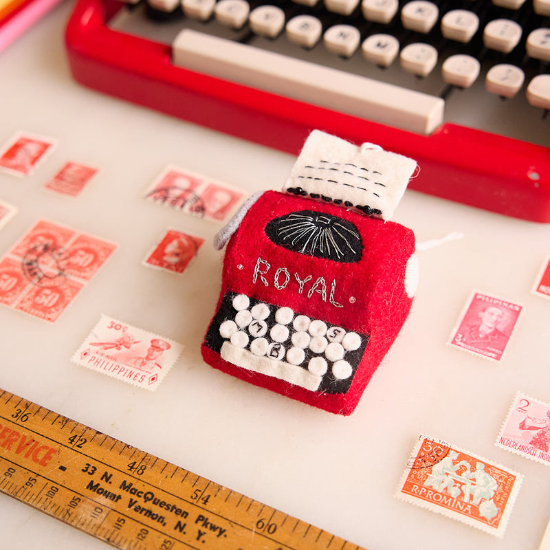 Hand-felted red typewriter ornament inspired by the 1955 Royal Quiet De Luxe, with embroidered keys and vintage design. Handmade and fair trade.

