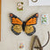 Handmade felt monarch butterfly ornament with embroidered details and beading in orange and black