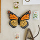Handmade felt monarch butterfly ornament with embroidered details and beading in orange and black