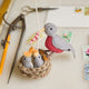 Handmade felt mama robin ornament feeding chicks in crocheted nest with embroidered details