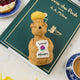 Festive hand-felted wool ornament of a honey bear jar, sparkling with beaded details and a stitched clover on its chest. Inspired by Winnie the Pooh, this cozy golden bear makes a charming holiday gift and nostalgic keepsake. Includes a hanging string and measures approximately 4.5 inches tall — perfect for tree decorating, gift-topping, or stocking stuffing.