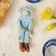 Hand-felted blue beekeeper ornament with brown hair, supporting pollinator awareness