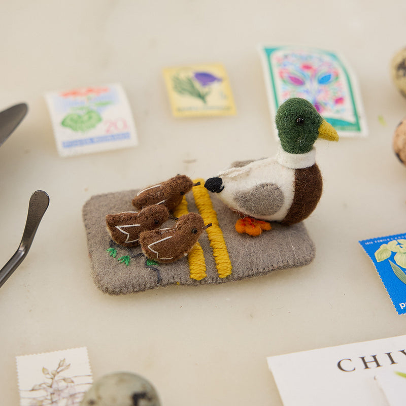 Handmade felt ornament of a mallard mama leading ducklings across a street, inspired by “Make Way for Ducklings.”