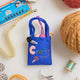 Hand-felted knitting bag ornament with colorful yarn balls and felt needles, celebrating handmade craft and creativity. Fair trade and artisan-made.

