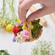 Colorful spring flower basket ornament made with raffia and felted merino wool