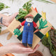Rustic felt Santa in overalls holding carrot—perfect holiday decor for gardeners and nature lovers