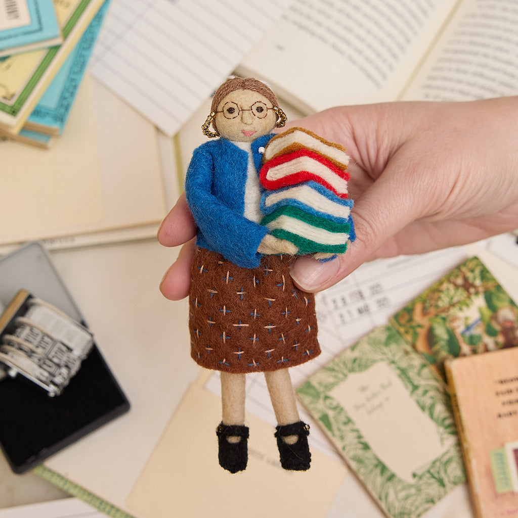 Natural wool librarian ornament with glasses and a book stack – celebrating the love of books and the magic of reading, from our Reading Collection.