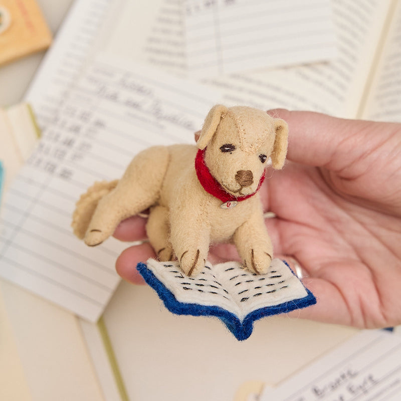 Handmade felt ornament of a cozy dog curled up with a book, from our Reading Collection – a heartwarming tribute to readers, writers, and literary hearts who find peaceful escape in stories.