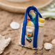 Handmade felt Beach Bag ornament from Craftspring, displayed on a sandy shore with seashells—heirloom-quality summer decor that brings sunny, coastal vibes to your celebrations, ethically crafted by artisans in India using sustainable wool.