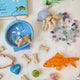 Craftspring’s handmade felt Hamster on a Wheel, Goldfish, and Hermit Crab Christmas ornaments displayed together among pet supplies—featuring charming embroidered details, perfect for whimsical holiday gifting, ethically crafted by artisans using sustainable wool.