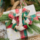 Handmade felt Anchor ornament from Craftspring, featuring beaded barnacles, appliqué seaweed and starfish, and draped in netting—displayed on a Christmas gift, perfect for nautical holiday decor, sustainably handmade by artisans using wool.