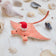 Handmade felt Santa Coral Manta ornament from Craftspring, featuring intricate beaded and embroidered details and a festive Santa hat—displayed among shells for a whimsical coastal Christmas scene, ethically crafted by artisans using sustainable wool.